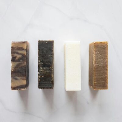 Top view of composition with handmade aromatic soap placed on white background in bathroom