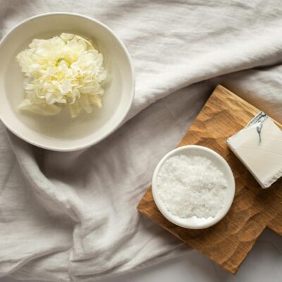 Washcloth in bowl with water near organic scrub and soap